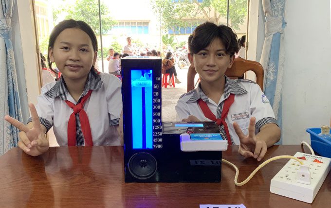 Thiên Ân and Vỹ beside the Library of Marine Life by Water Depth model.
