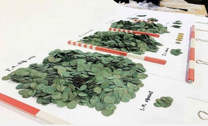 While digging, the farmer accidentally found a jar of ancient coins.