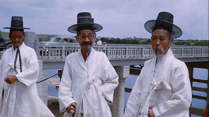 Three elderly men posing in traditional white clothing