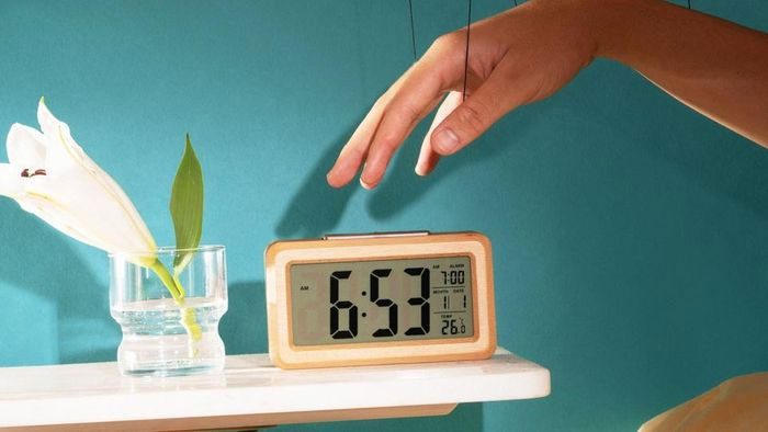 An illustration of an alarm clock placed on a bedside table.