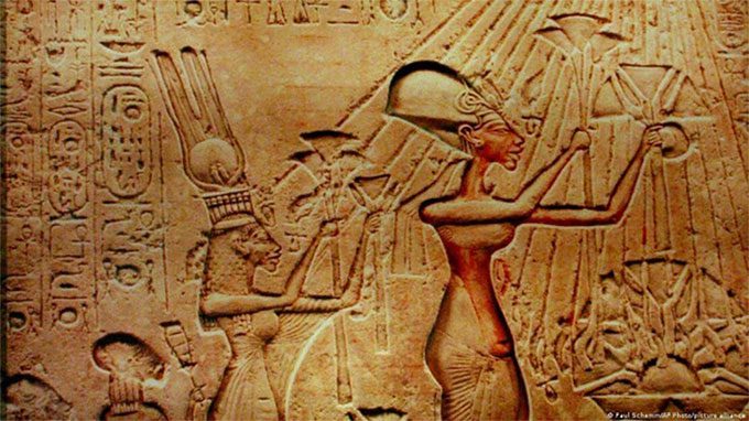 Ancient relief: Pharaoh Akhenaten and Queen Nefertiti worshipping the sun god Aten.
