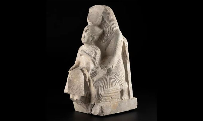 Ancient Egyptian artwork depicting a man holding a statue of the pharaoh.