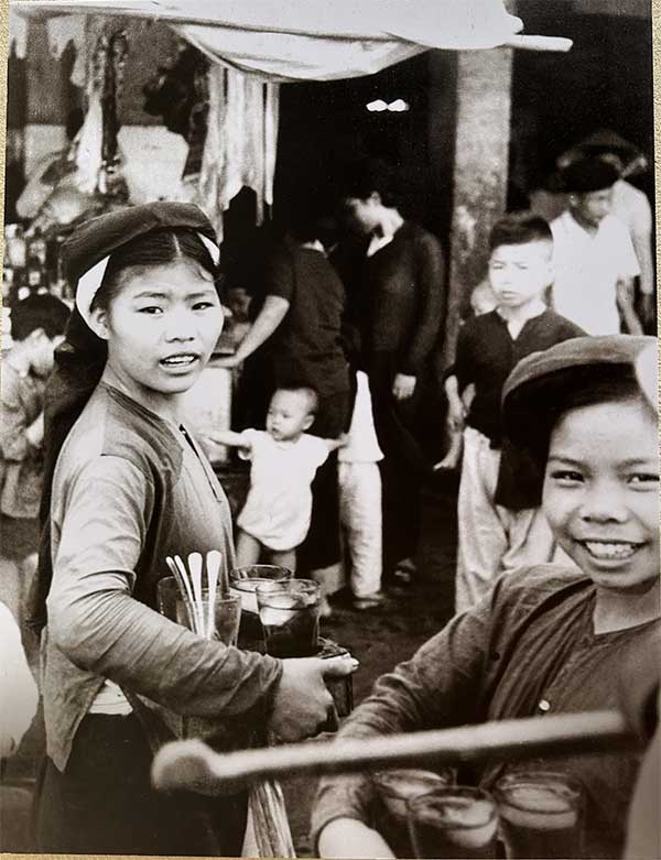 Children selling pomegranate syrup near Đồng Xuân Market in 1951.