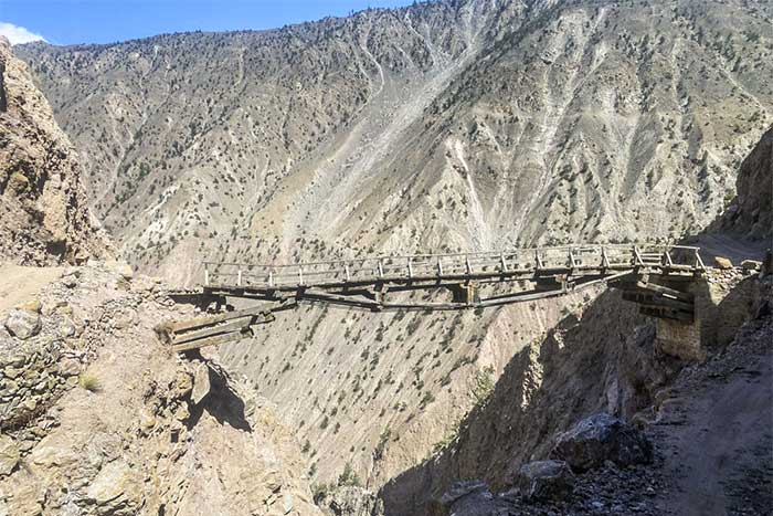 A wooden bridge built precariously between two cliffs.