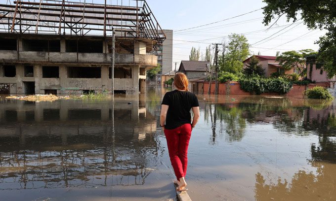 A woman observing the flooded road in Kherson after the Kakhovka Dam breach on June 6.