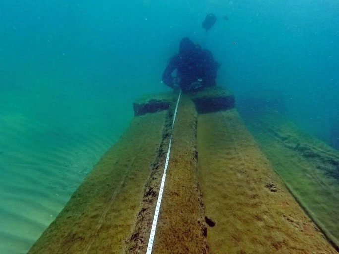The marble column being measured underwater