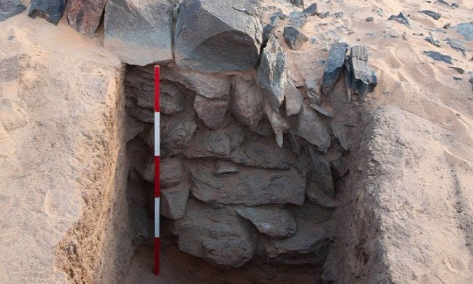 Excavation of a dike in a dry water channel reveals the thick sediment layer of the Nile.