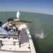 giant fish jumping over boat beneath arrow fisherman 128087