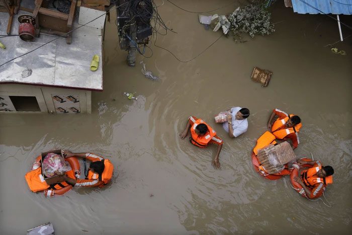 Relief workers distribute items to flood-affected individuals