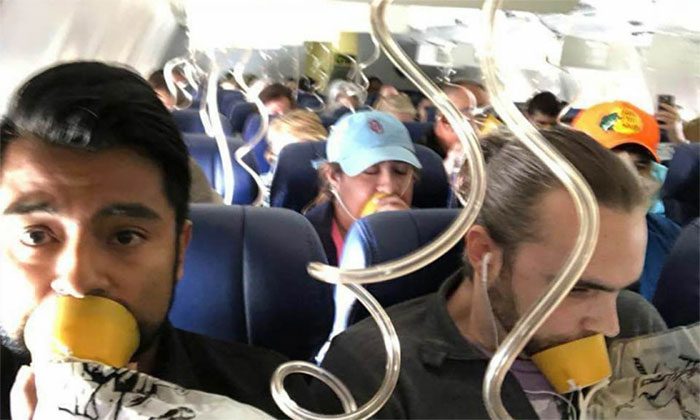 Passengers wearing oxygen masks during an emergency.