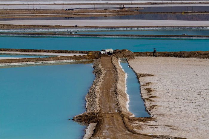 The color change in the pond is due to variations in the lithium concentration in the water.