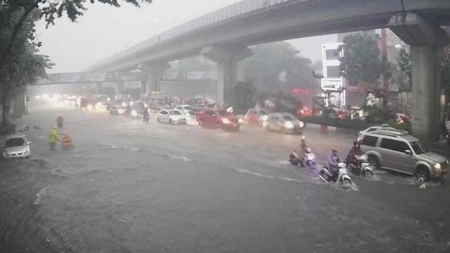 Rain caused water on Nguyen Trai Street to rise above half the wheel of a motorcycle on June 12, 2023.