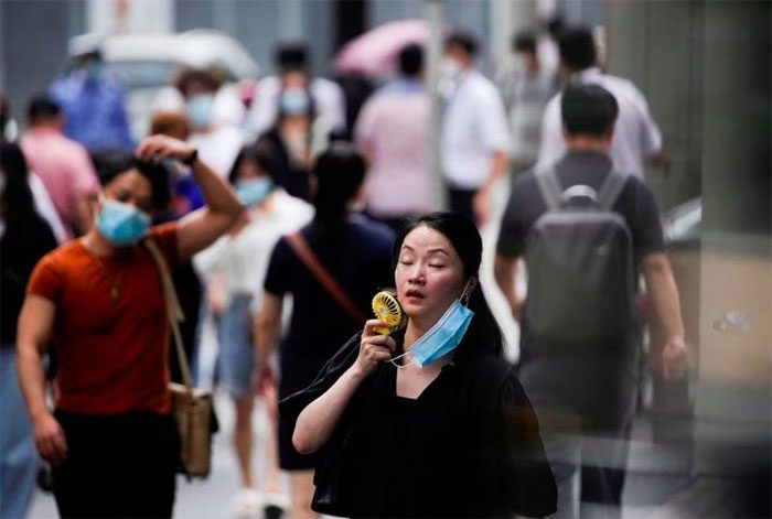 A woman uses a fan in Shanghai, China during the record heat wave.