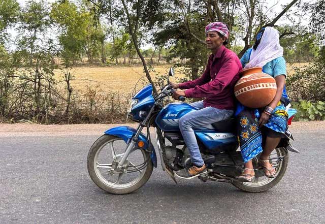 A woman carries an earthen pot for storing drinking water