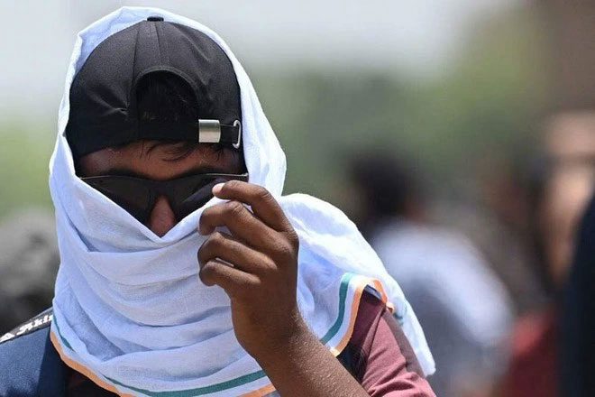 A man using a scarf to avoid the heat in New Delhi, India