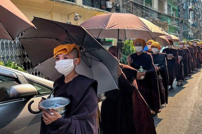 Nuns collecting alms with headscarves and umbrellas to avoid the sun