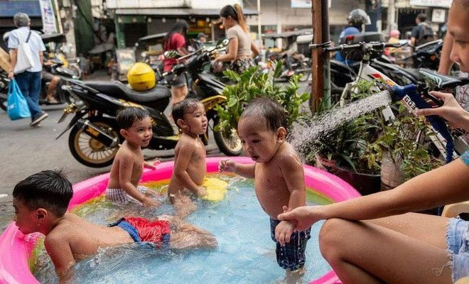 Children playing in an inflatable pool by the roadside