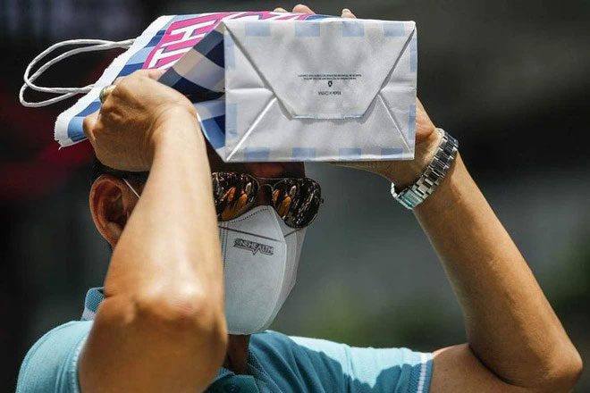 A man covering his head with a paper bag on a hot day in Kuala Lumpur