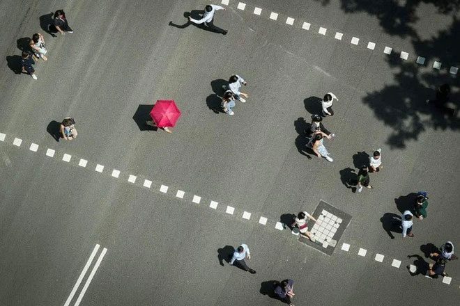 People crossing the street at Raffles Place, Singapore, on May 3, 2023.