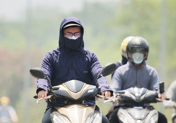 People participating in traffic under the hot sun on Thang Long Avenue, Hanoi.