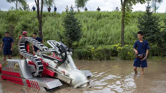 Firefighters operating a drainage machine near a village in Mudanjiang City