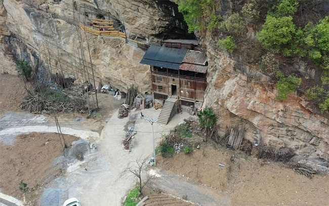 The house appears to be nestled within the cliff.
