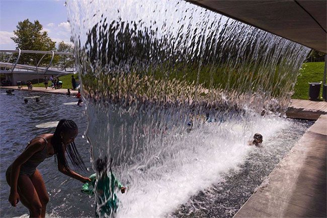 People cooling off by a fountain in Washington, D.C., USA, on July 11, 2023.