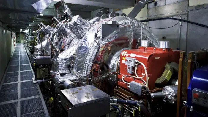 The antiprotons will pass through four-pole magnets (in red) and be compressed.