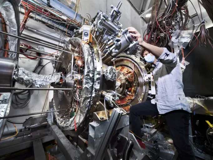 A person is checking equipment in CERN's facility.