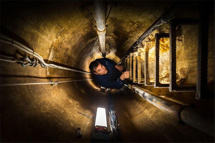 An electrician descending into the tunnel system during his shift