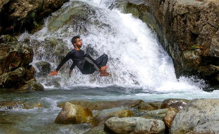 A man jumps into a stream to escape the heat in the outskirts of Srinagar, India, on July 5.