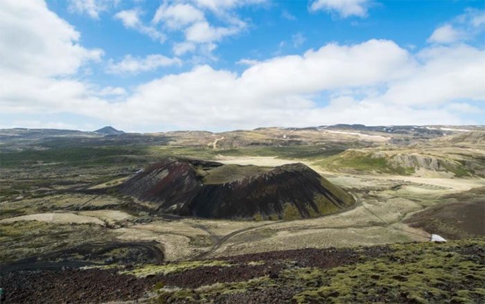 The grassy crater combined with the black soil slopes looks pristine and majestic.