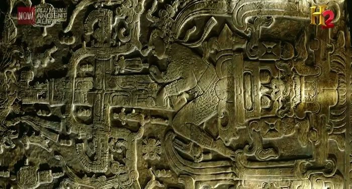 The stone slab depicting a human in the ruins of a Maya temple.