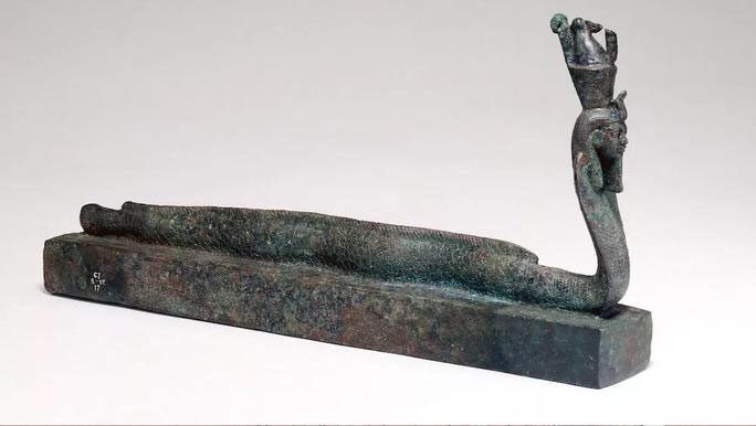 A hybrid creature of an eel, a snake, and a deity atop an Egyptian coffin