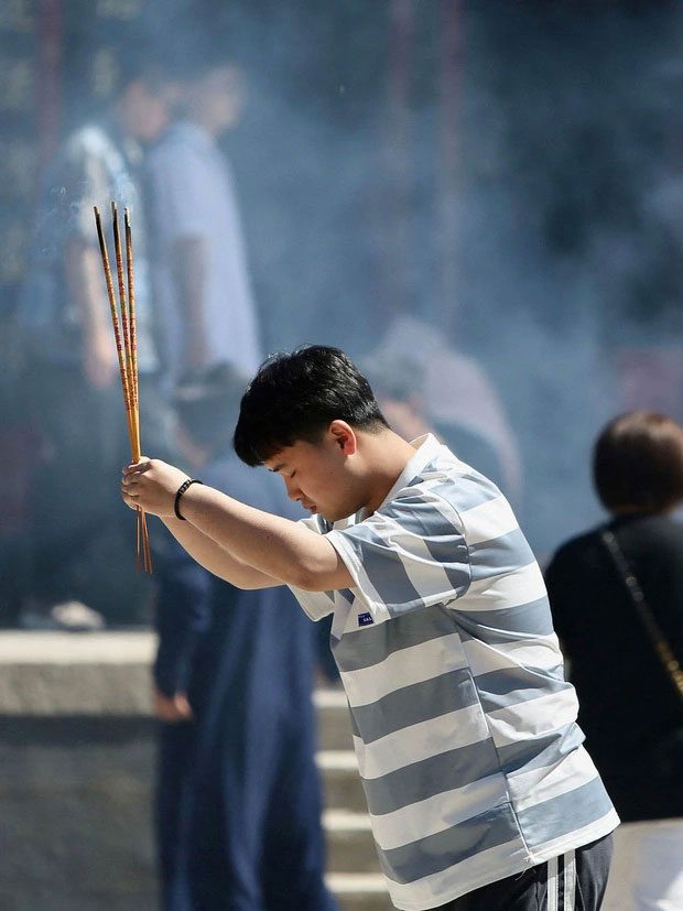 Chinese candidates pray for good luck before entering the decisive university entrance exam.