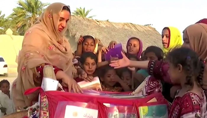Children excitedly welcome Ms. Jalal and the Camel Library to their village.
