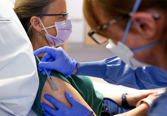 Nurse administering the third dose of the experimental breast cancer vaccine to patient Kathleen Jade