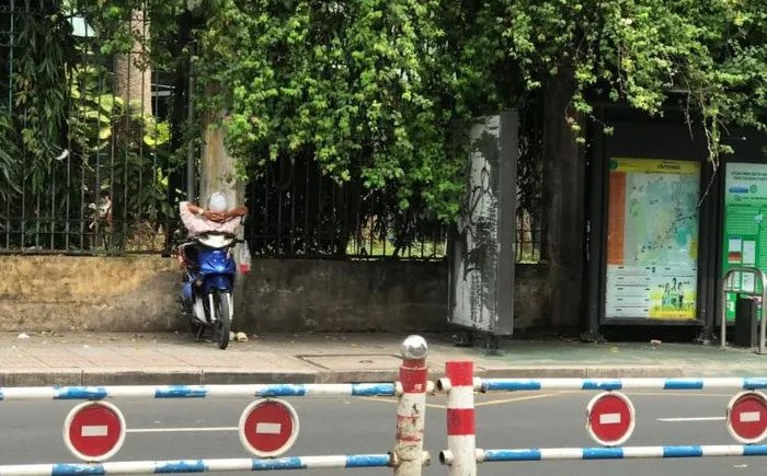 A motorbike taxi driver sleeps on his motorcycle in Vietnam.