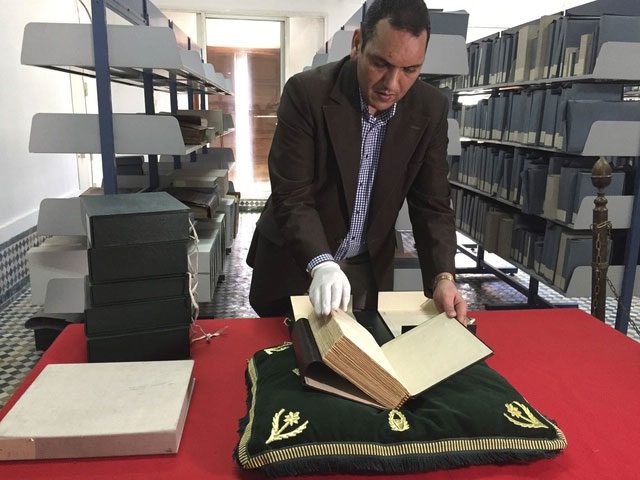 Mr. Abdelfattah Bougchouf - the custodian of Al-Qarawiyyin opening an ancient book in the library