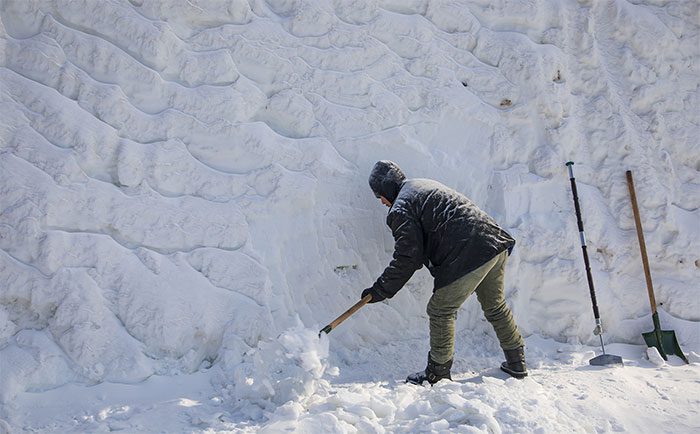 Jiangtan Park staff creating artistic snow sculptures.