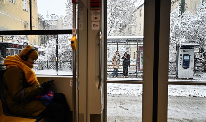 Residents waiting for a bus in winter in Kraków, Poland.