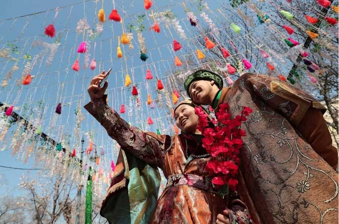 A couple taking pictures at the traditional Nowruz festival in Almaty, Kazakhstan