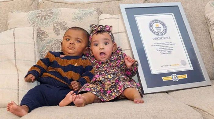 Adrial (left) and Adiah sitting next to the certificate recognizing them as the world's most premature twins