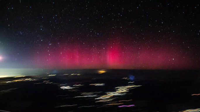 Mysterious pink aurora in the sky of the United States captured from an airplane window