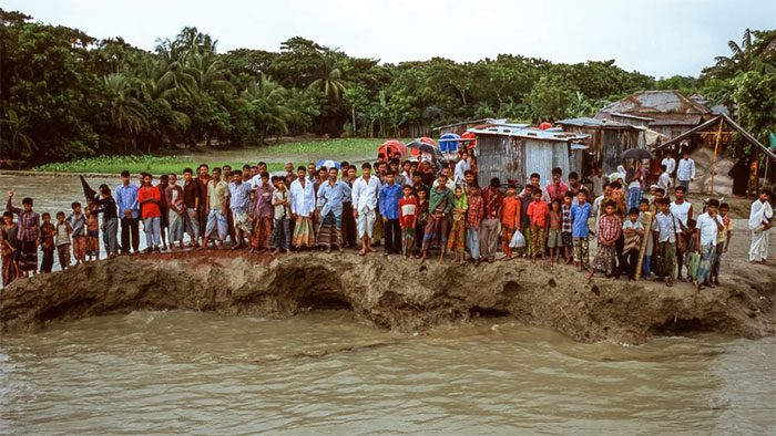 Villagers stand on the remnants of a road on Bhola Island, Bangladesh, in 2005.