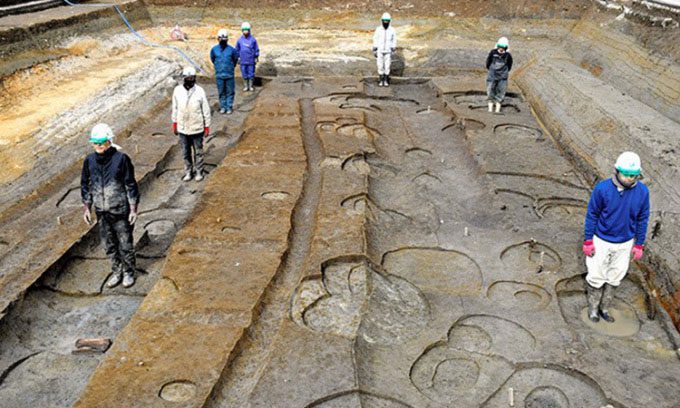 Researchers standing at the site of the giant wooden pillars in the residence of Prince Toneri