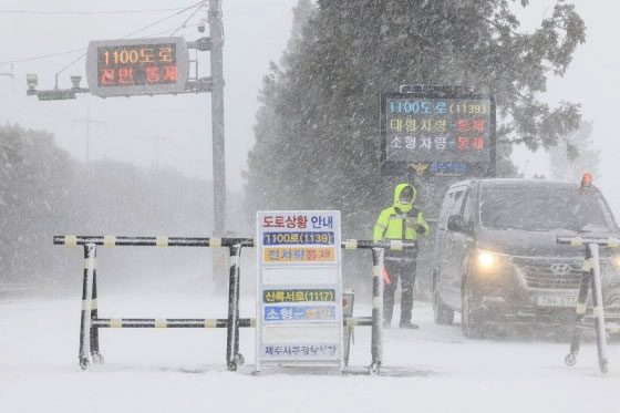 Traffic police directing vehicles on Jeju Island on January 24.