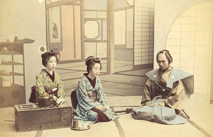 Two geishas receiving a samurai visitor, circa 1880