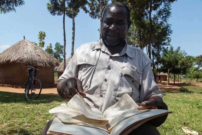 Musa Hasahya holding notebooks detailing his family's history.