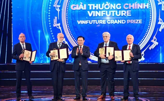 Chairman of the National Assembly Vuong Dinh Hue (center) presents the award to 4 authors of the Grand Prize on the evening of December 20 in Hanoi.
